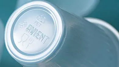 Close-up of clear plastic cups stacked together, showing an embossed recycling symbol and branding on the base.